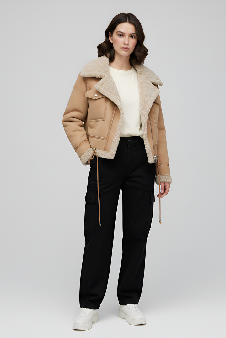 Woman wearing a beige shearling jacket on a white background