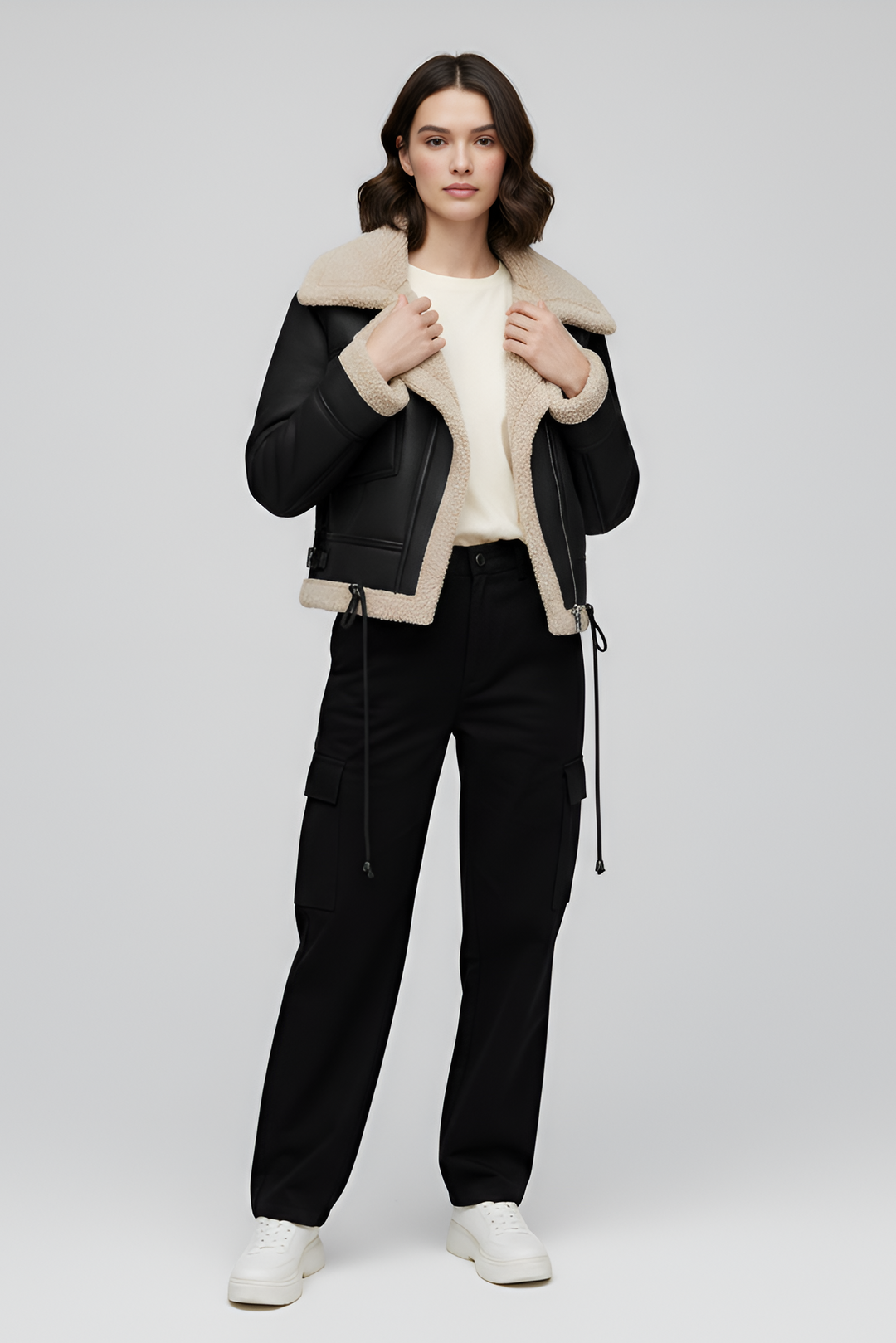 Woman wearing a black and beige shearling jacket on a white background