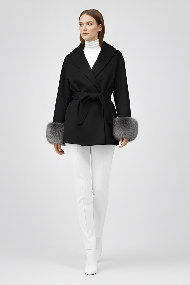 Woman wearing a black coat with fur cuffs on a white background