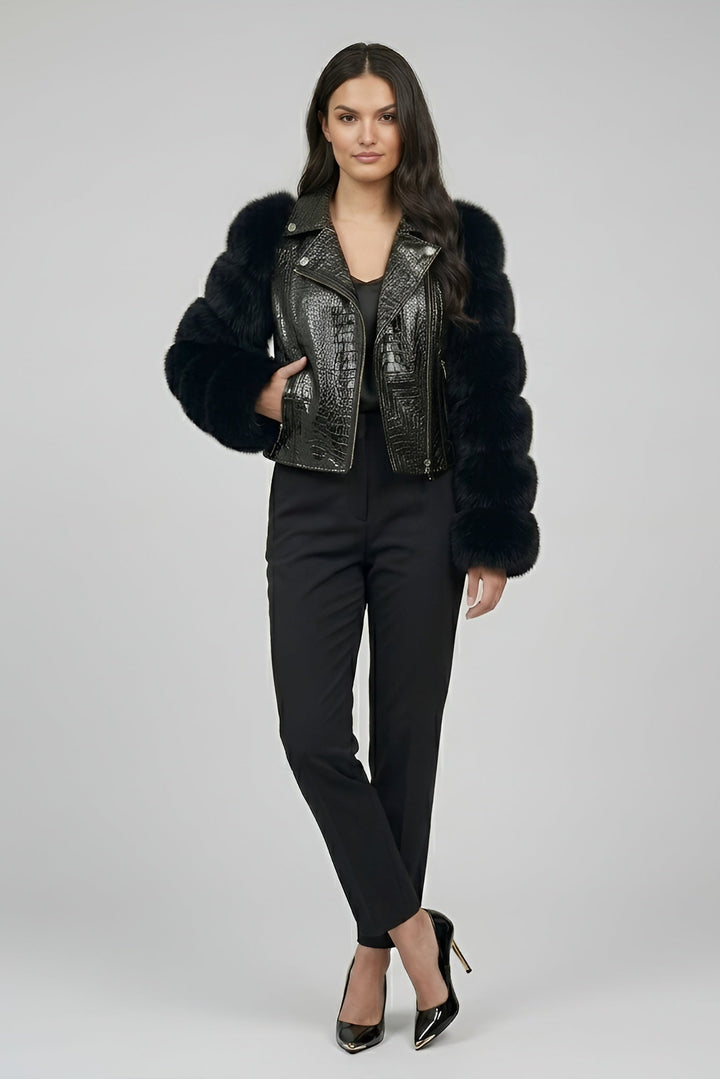 Woman wearing a black fur-trimmed leather jacket on a gray background