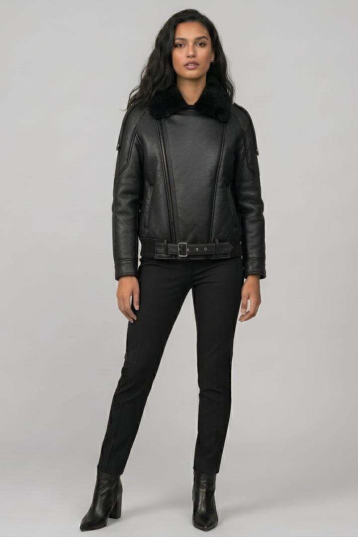 Woman wearing a black leather jacket and pants on a gray background