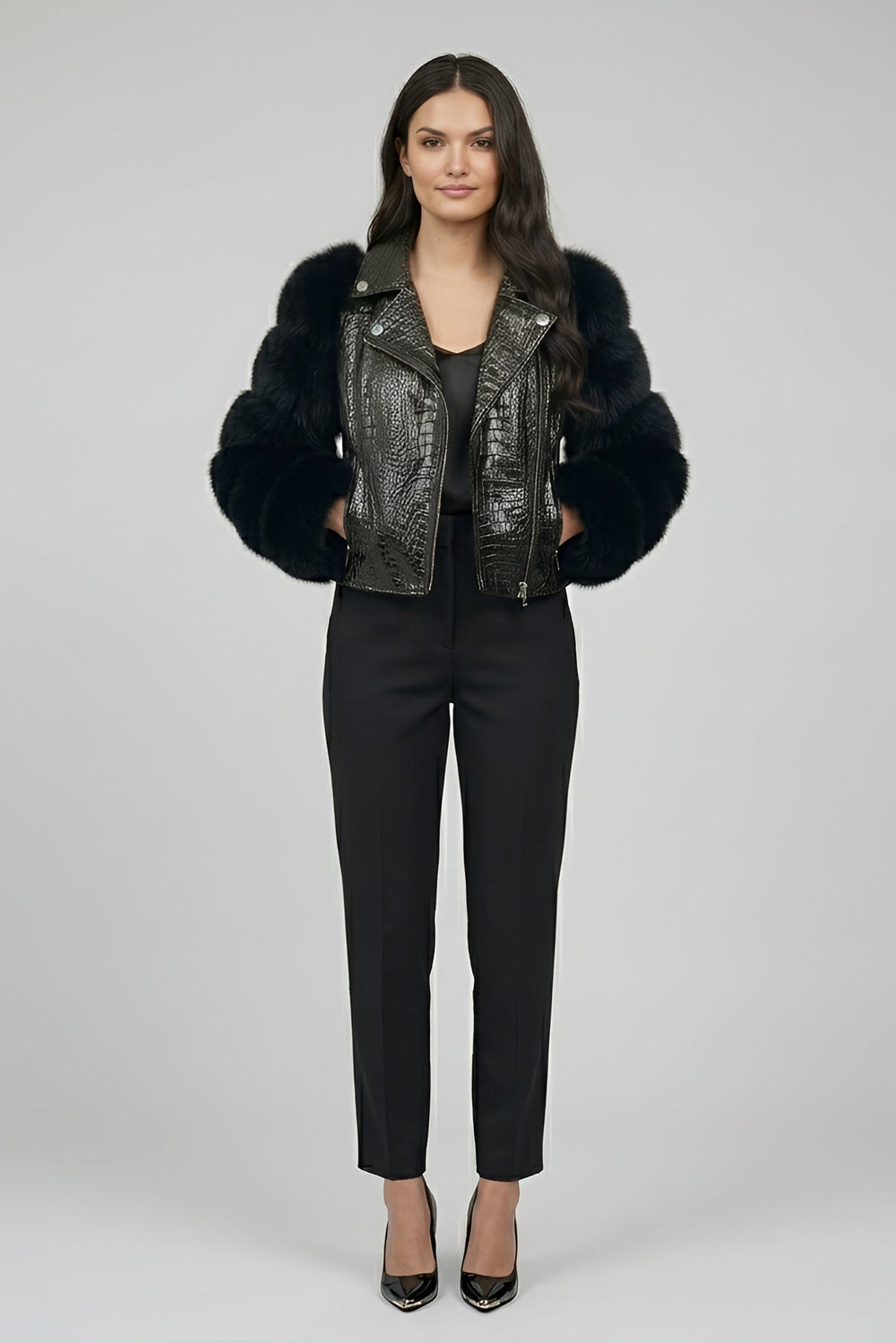 Woman wearing a black leather jacket with fur trim on a gray background