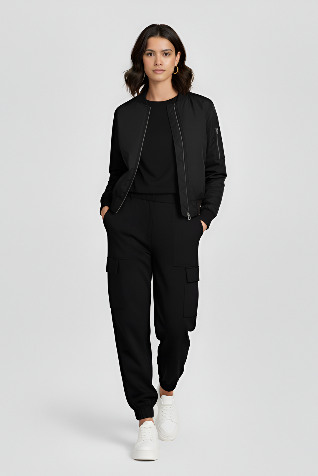 Woman wearing a black outfit with white sneakers on a light gray background