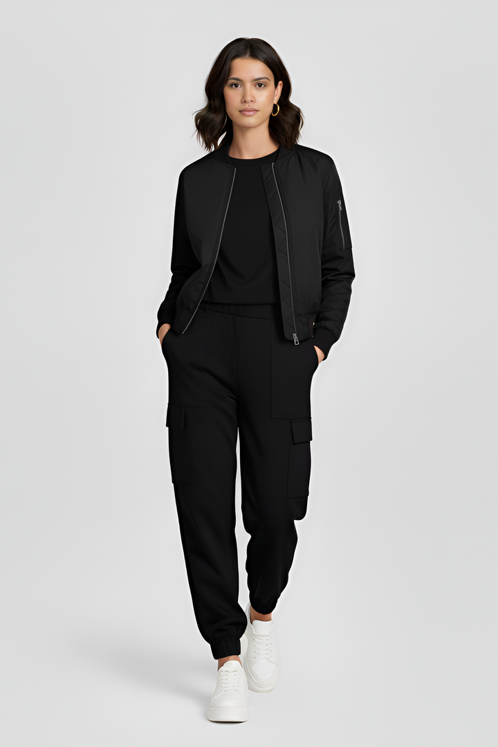 Woman wearing a black outfit with white sneakers on a light gray background