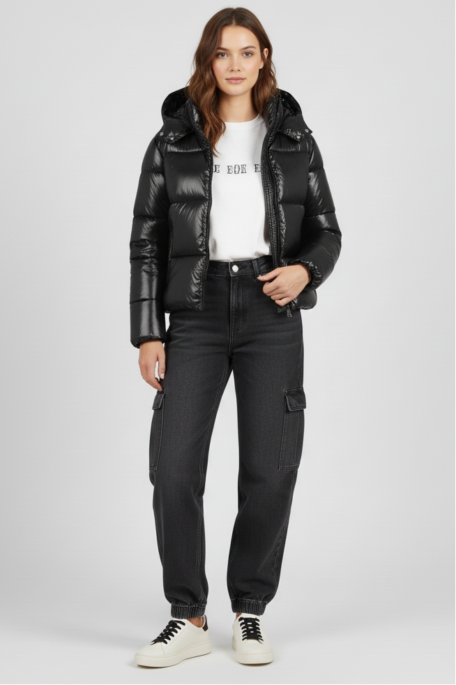 Woman wearing a black puffer jacket and black pants on a white background