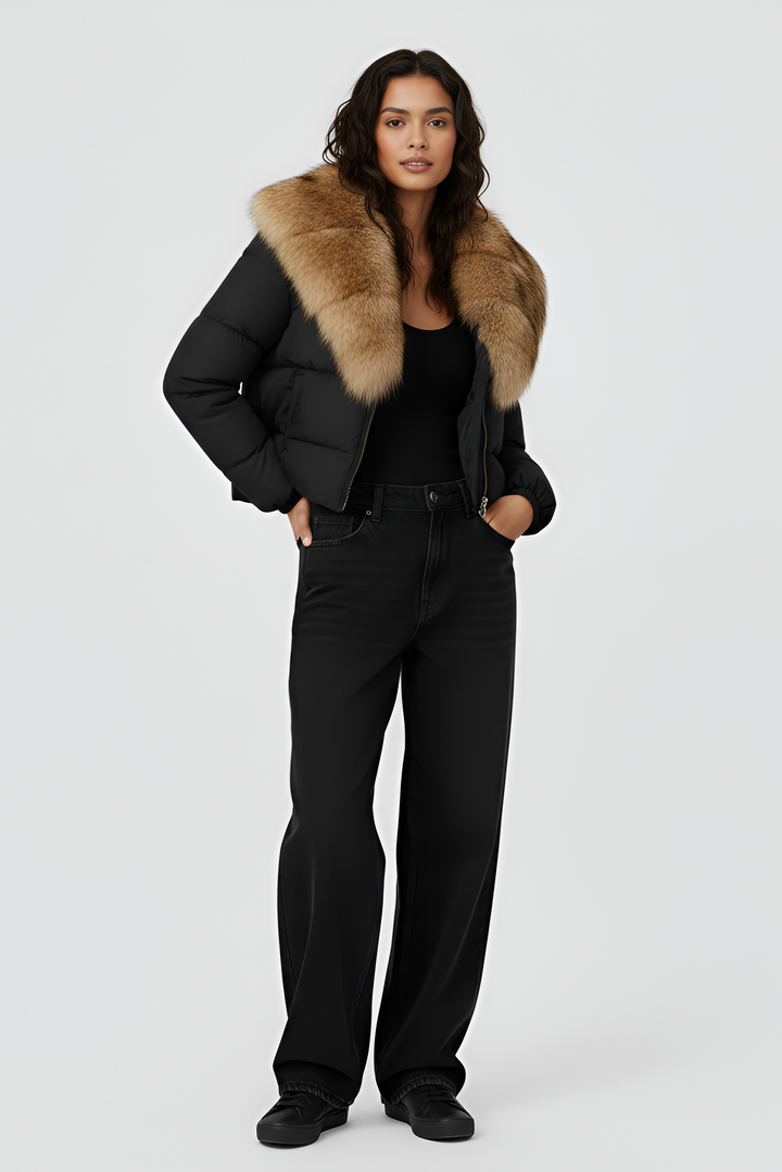 Woman wearing a black puffer jacket with a fur hood on a white background