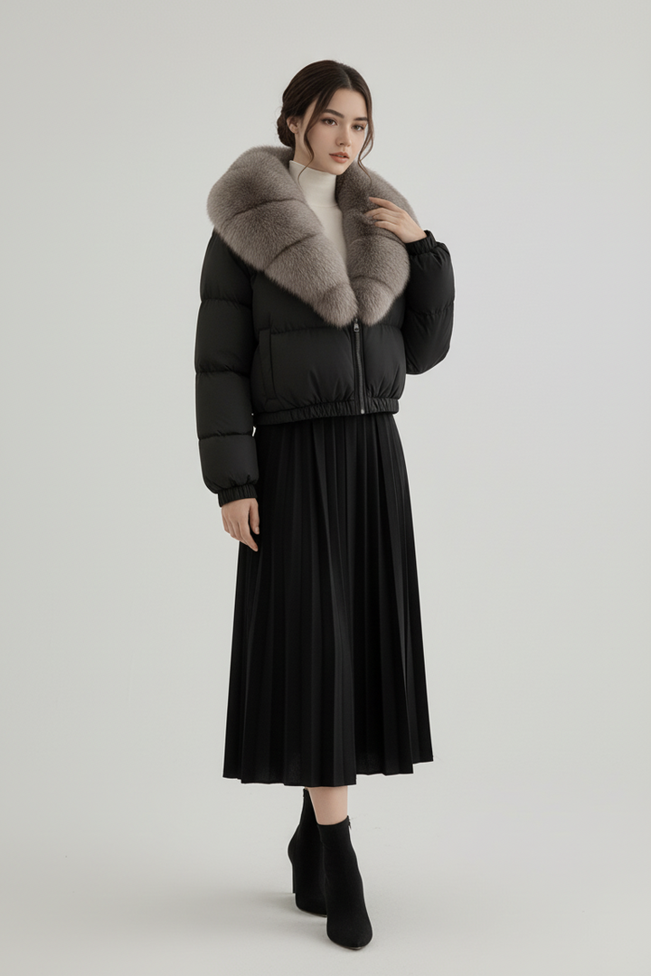Woman wearing a black puffer jacket with fur collar and a black skirt on a white background