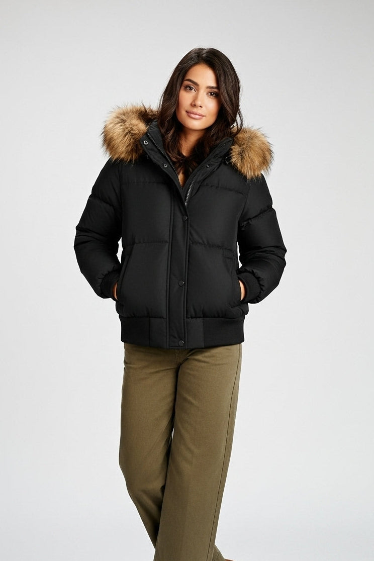 Woman wearing a black puffer jacket with fur hood on a white background