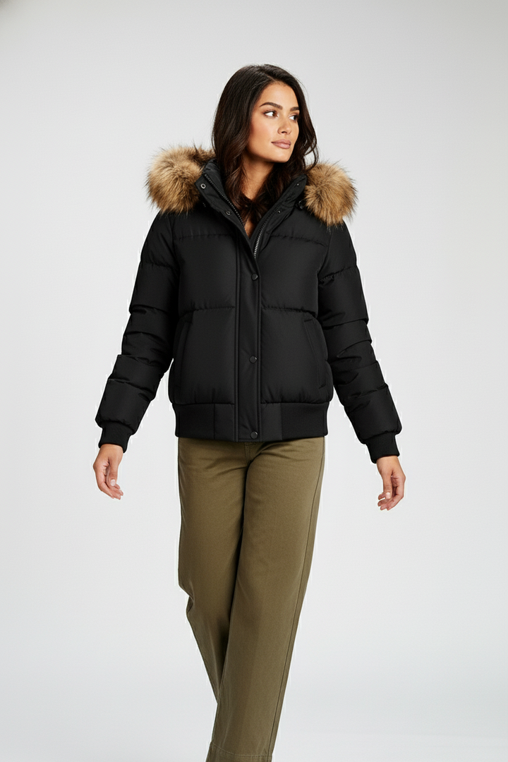 Woman wearing a black puffer jacket with fur hood on a white background