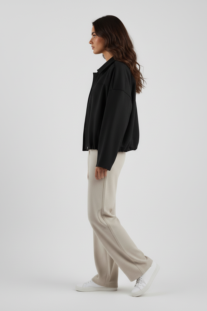 Woman wearing a black shirt and beige pants on a white background