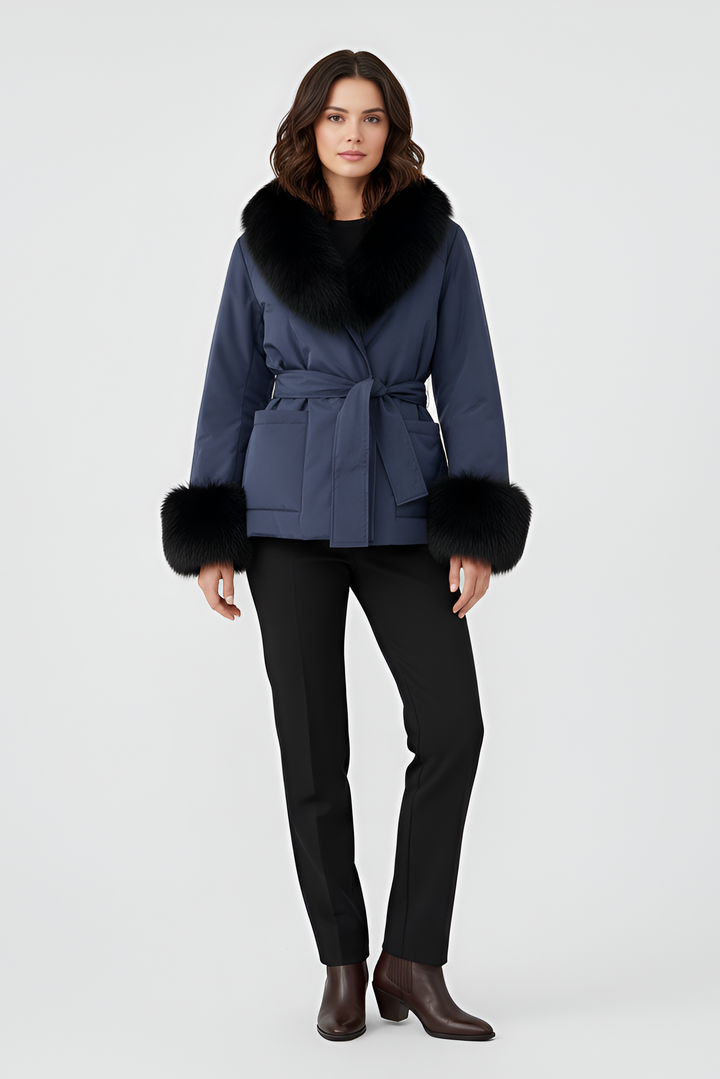 Woman wearing a blue coat with black fur trim on a white background