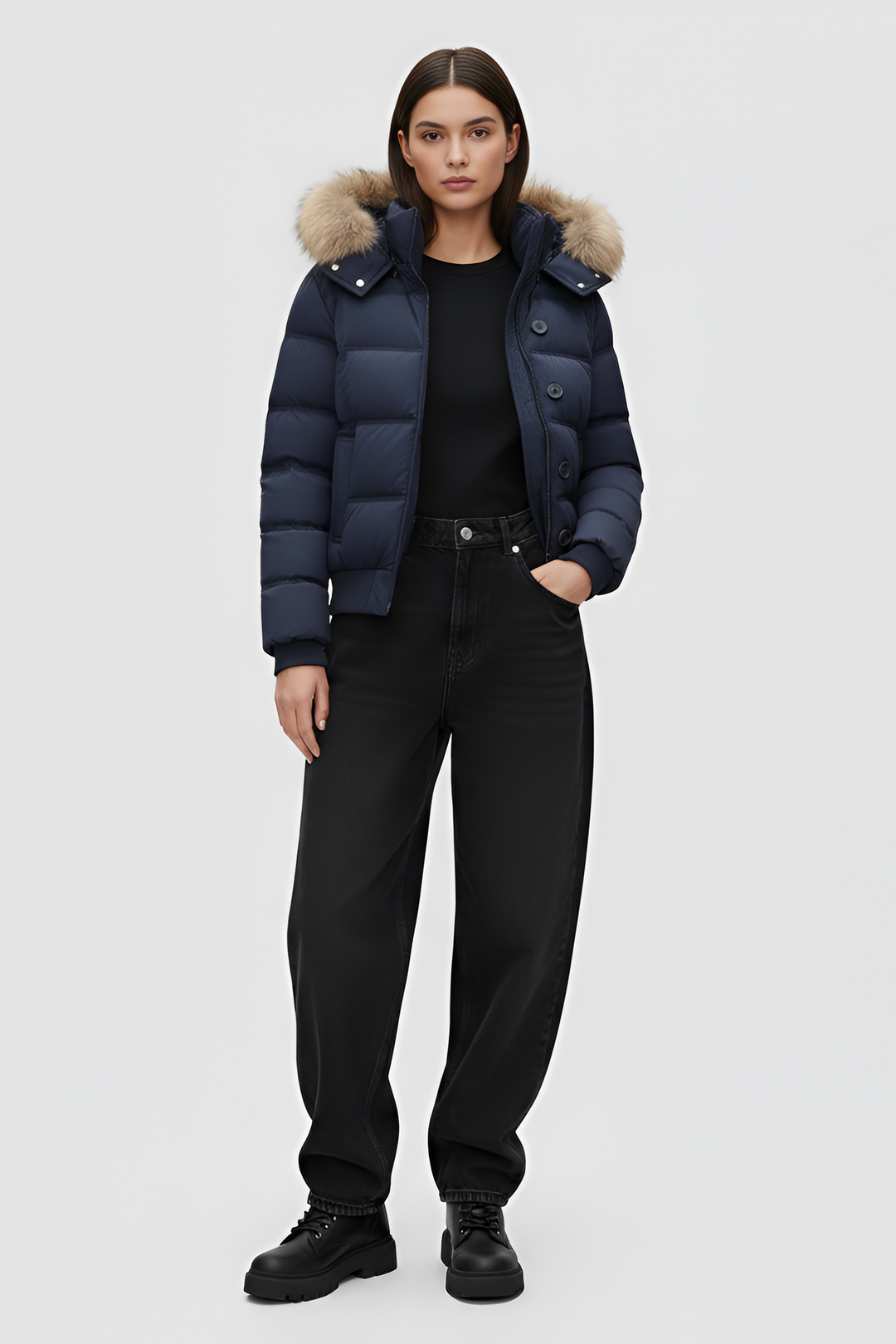 Woman wearing a blue puffer jacket, white shirt, and gray pants on a plain background