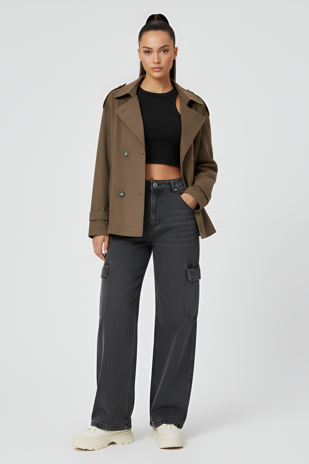 Woman wearing a brown coat and black pants on a white background