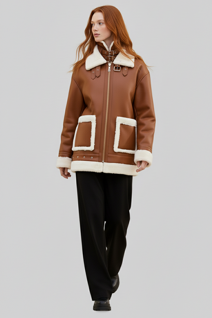 Woman wearing a brown coat with white fur trim on a gray background