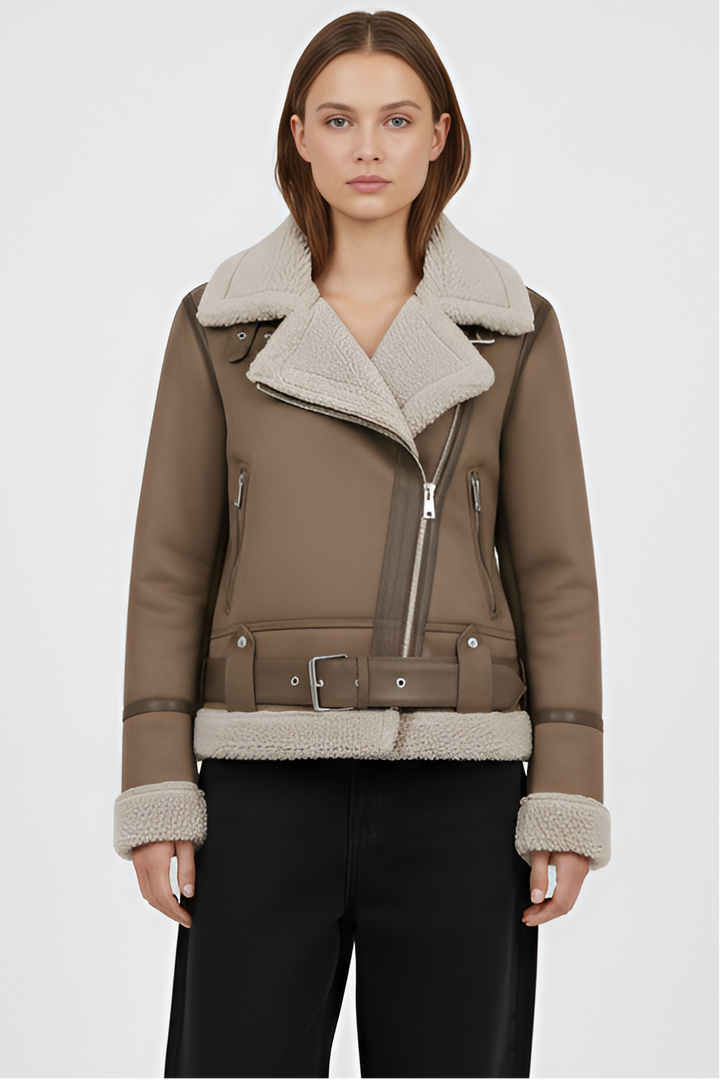 Woman wearing a brown shearling jacket and pants on a light gray background