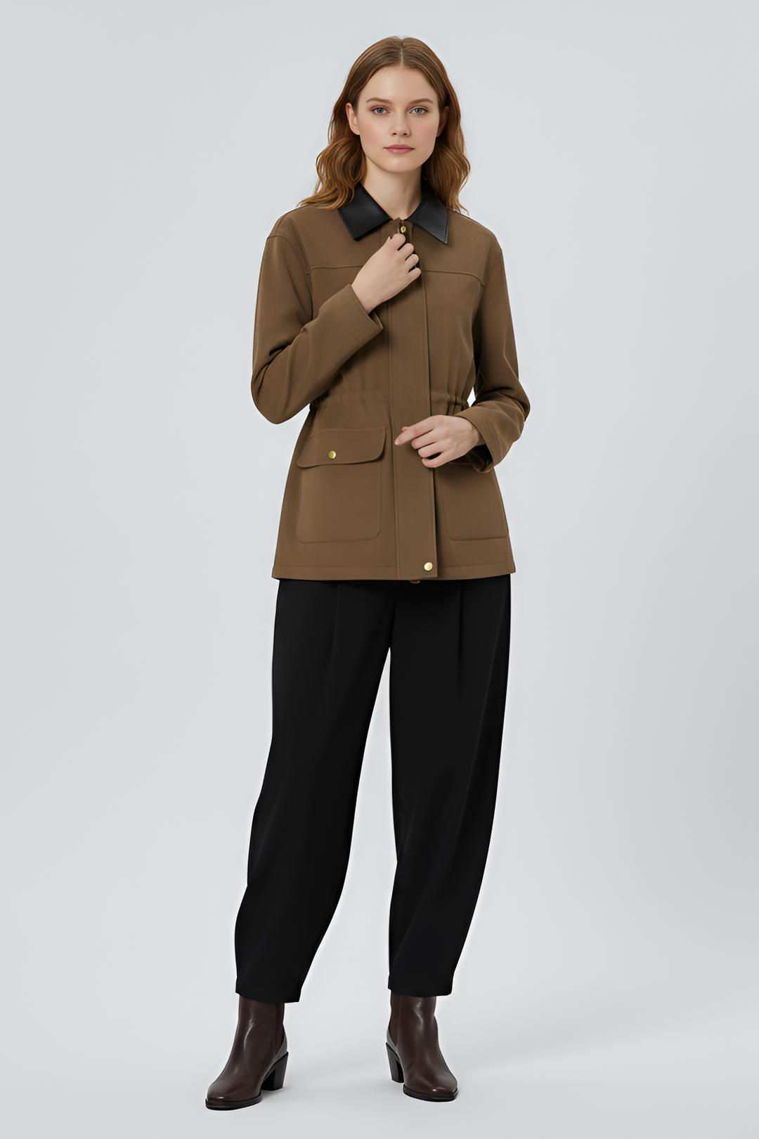 Woman wearing a brown jacket and black pants on a white background