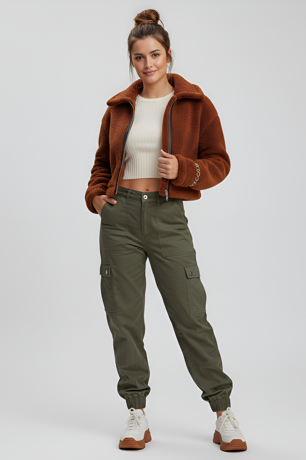Woman wearing a brown jacket and green cargo pants on a white background