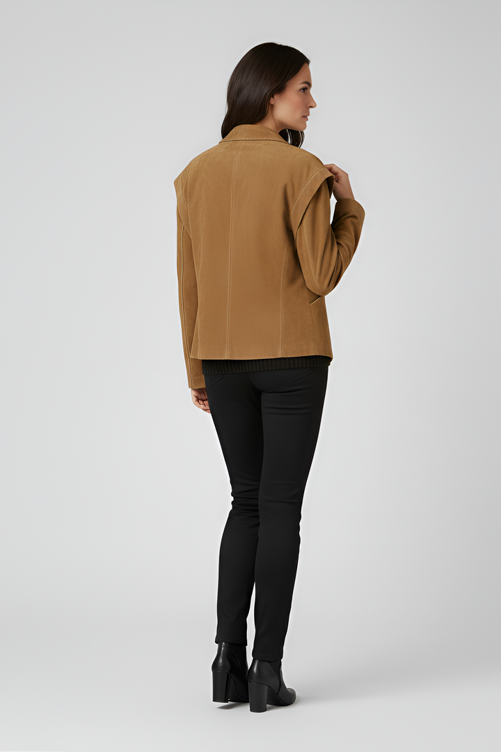 Woman wearing a brown jacket, black pants, and black boots side profile