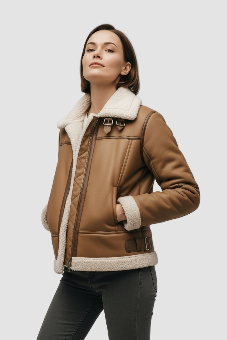 Woman wearing a brown leather jacket with white fur lining on a gray background