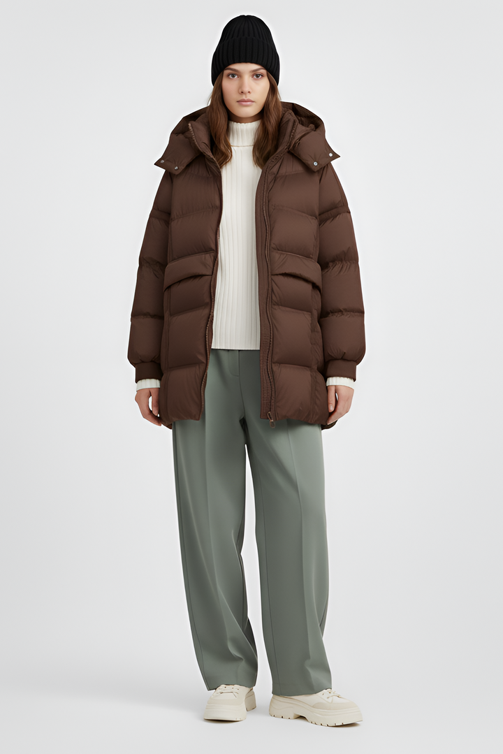 Woman wearing a brown puffer jacket on a light gray background