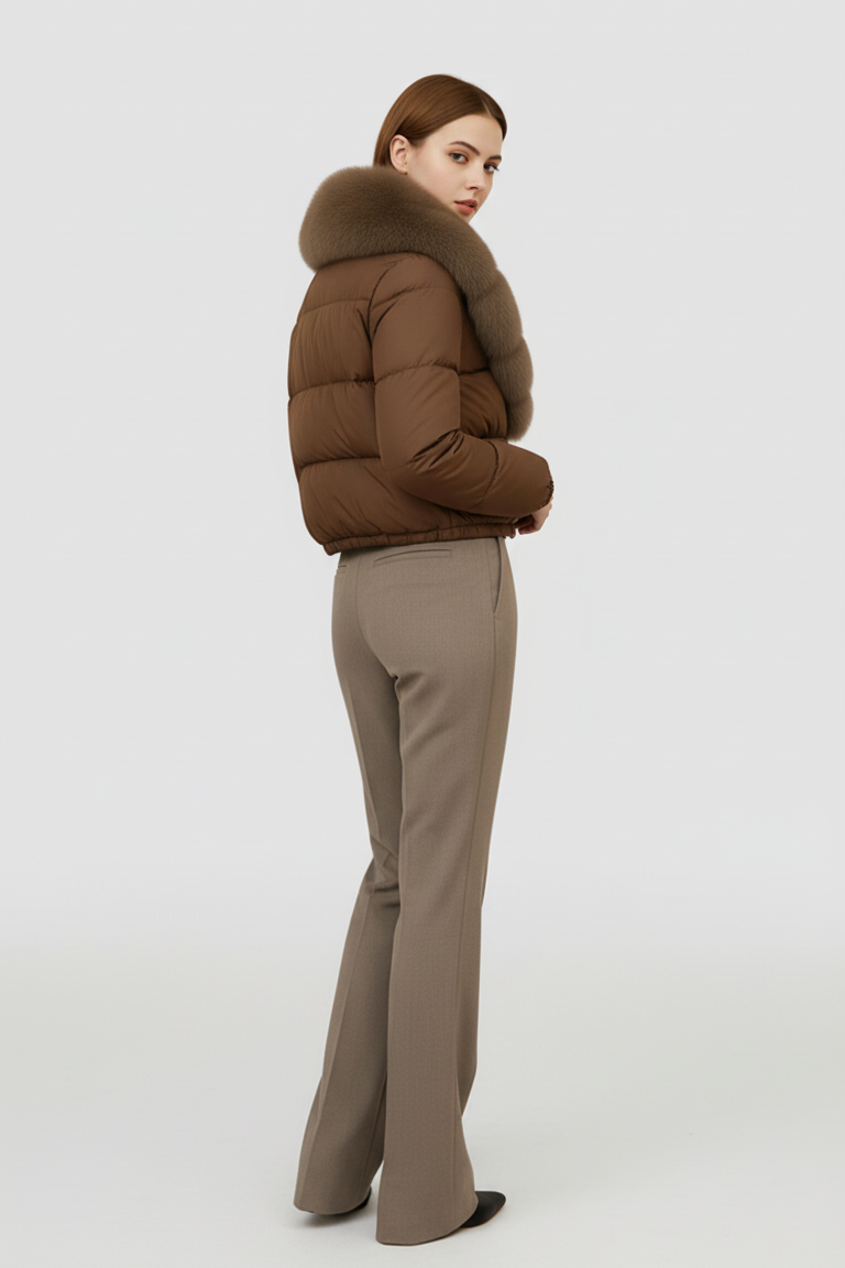 Woman wearing a brown puffer jacket and beige pants on a white background