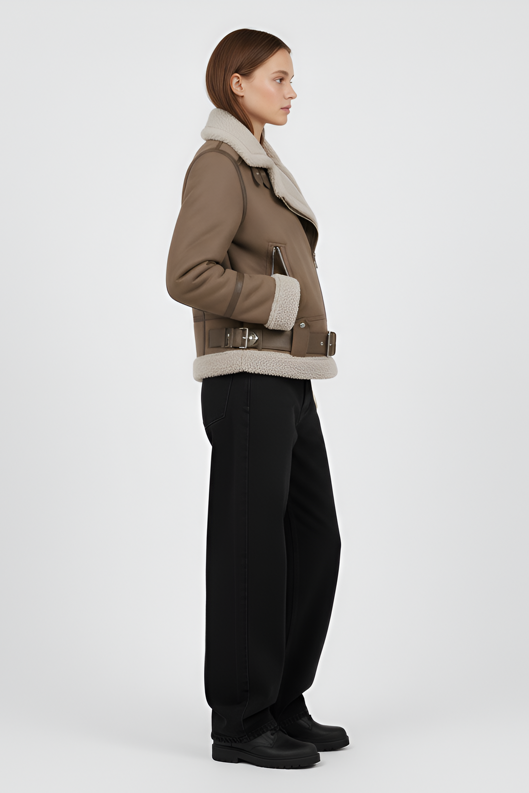 Woman wearing a brown shearling jacket and pants on a light gray background