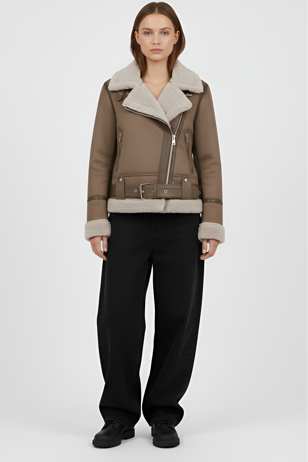 Woman wearing a brown shearling jacket and pants on a light gray background