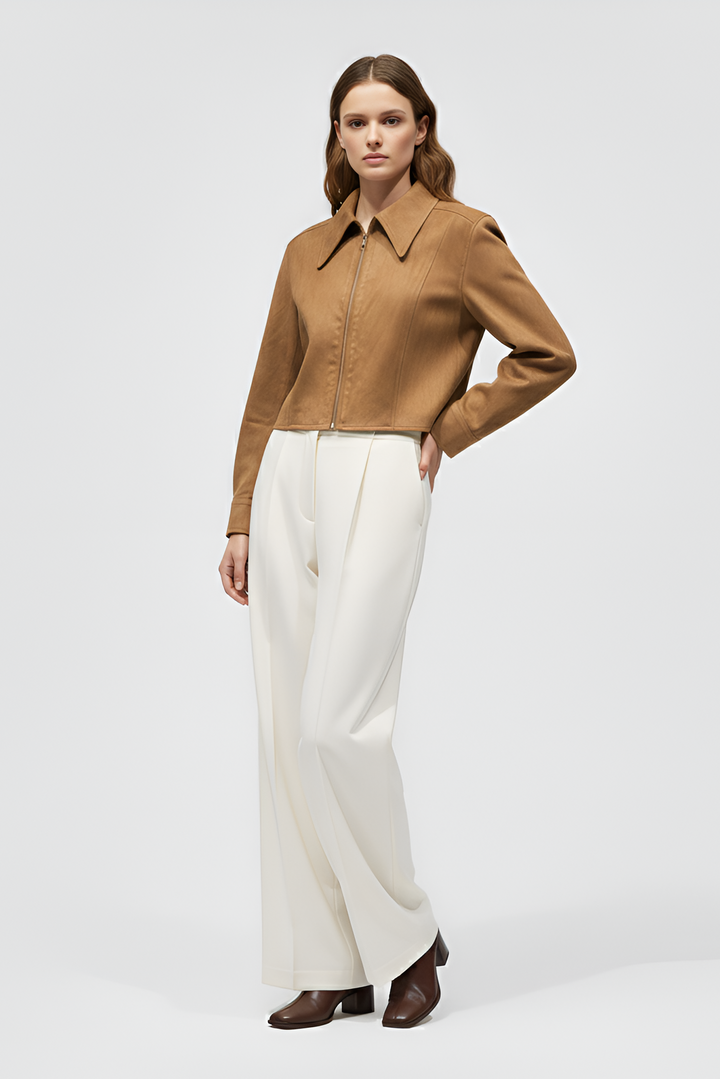 Woman wearing a brown shirt and white pants on a white background