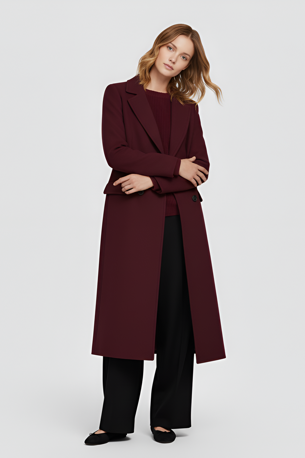 Woman wearing a burgundy coat and pants on a white background