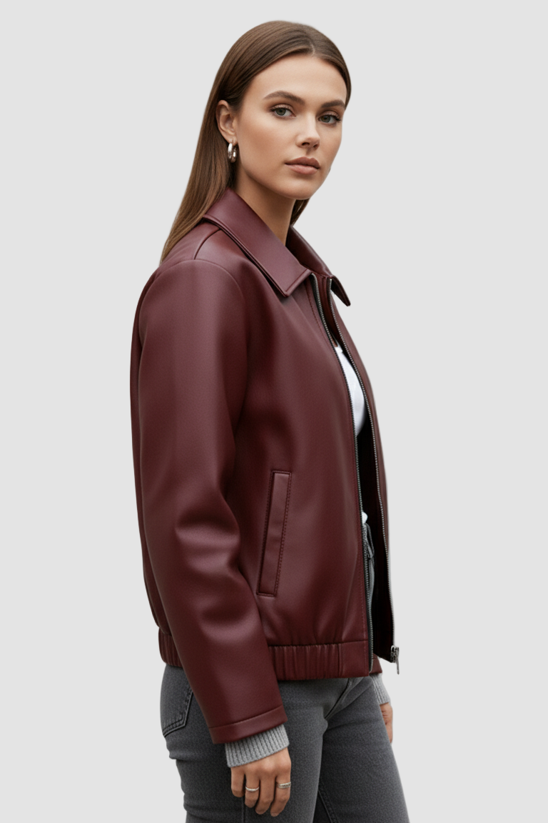 Woman wearing a burgundy leather jacket on a gray background