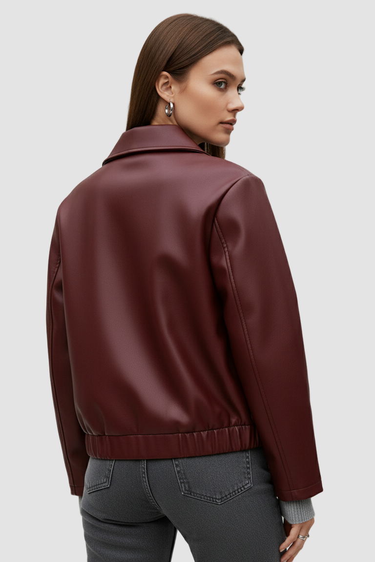 Woman wearing a burgundy leather jacket on a plain background