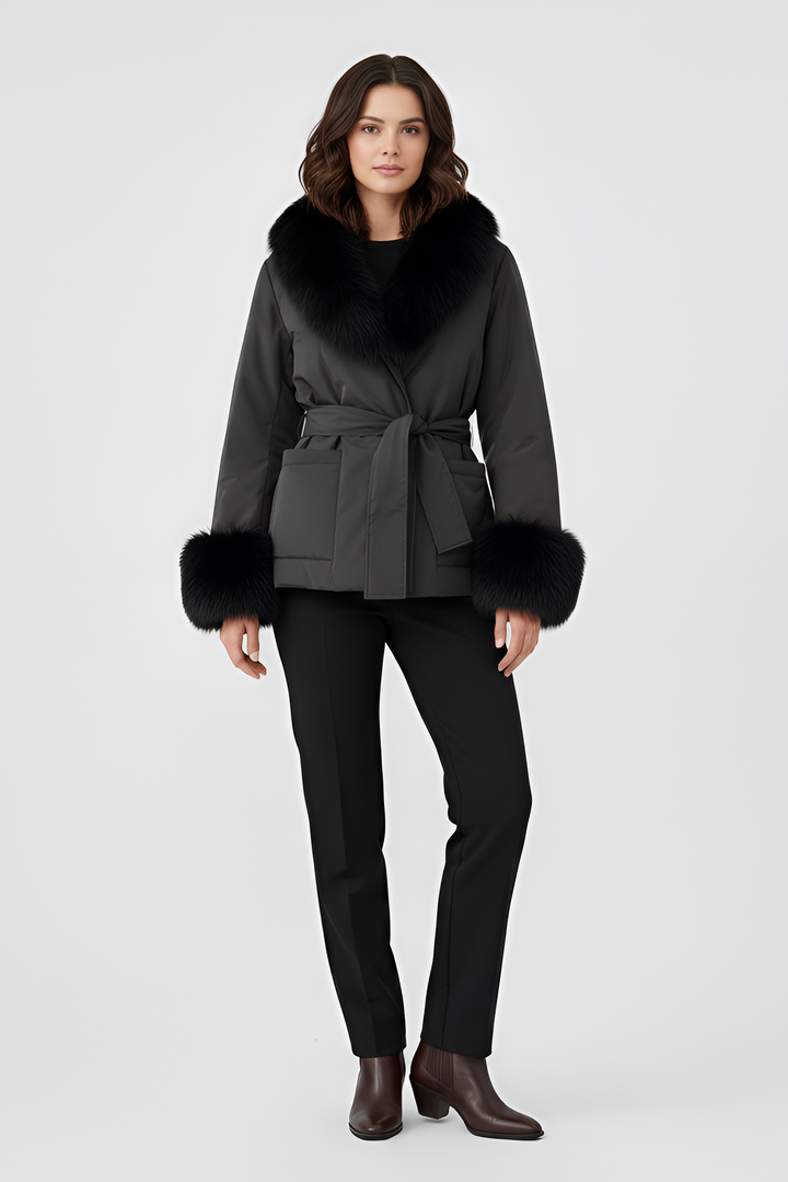 Woman wearing a dark gray coat with fur trim on a white background