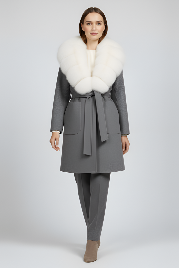 Woman wearing a gray coat with a white fur collar on a light gray background
