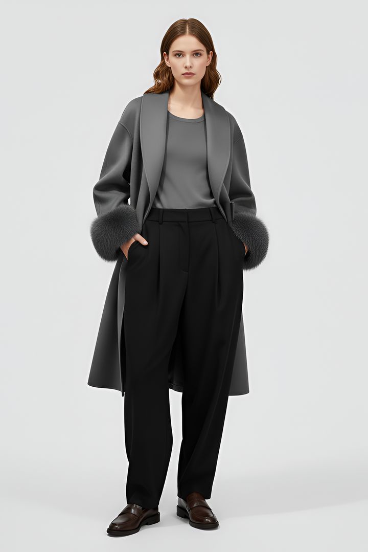 Woman wearing a gray coat with fur trim on a white background