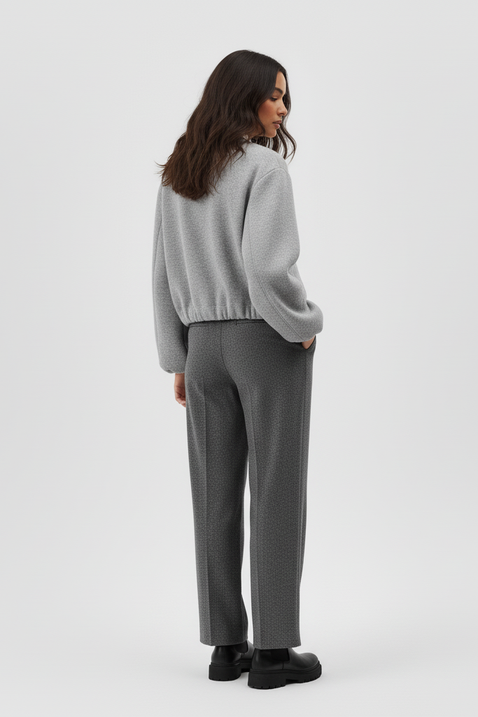 Woman wearing a gray sweater and pants on a white background