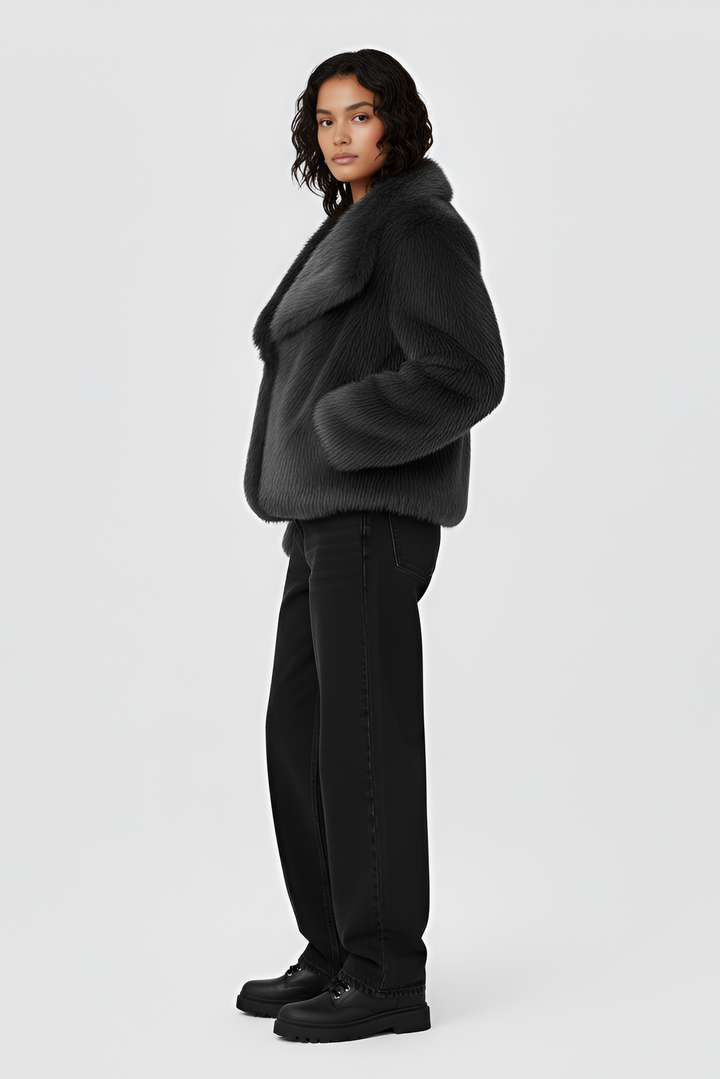 Woman wearing a gray sweater and white skirt on a plain background