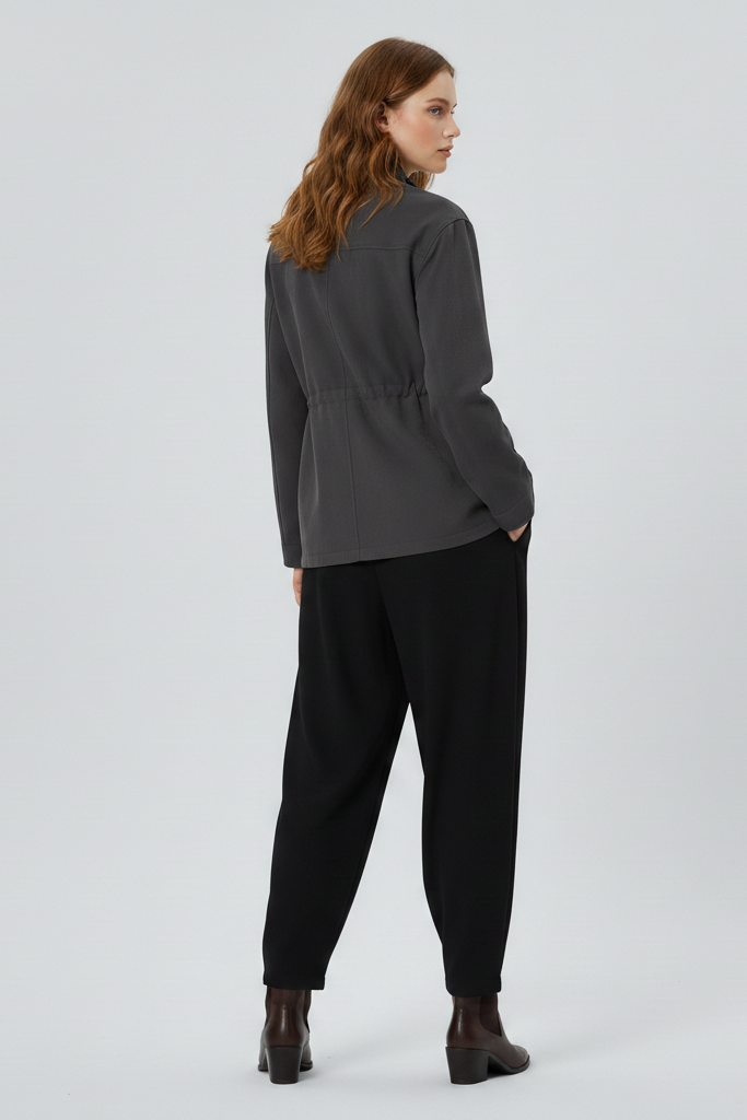 Woman wearing a gray top and black pants on a white background