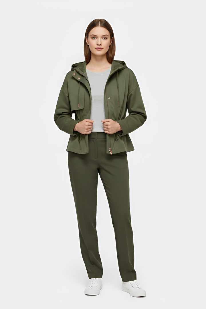 Woman wearing a green jacket and pants on a white background