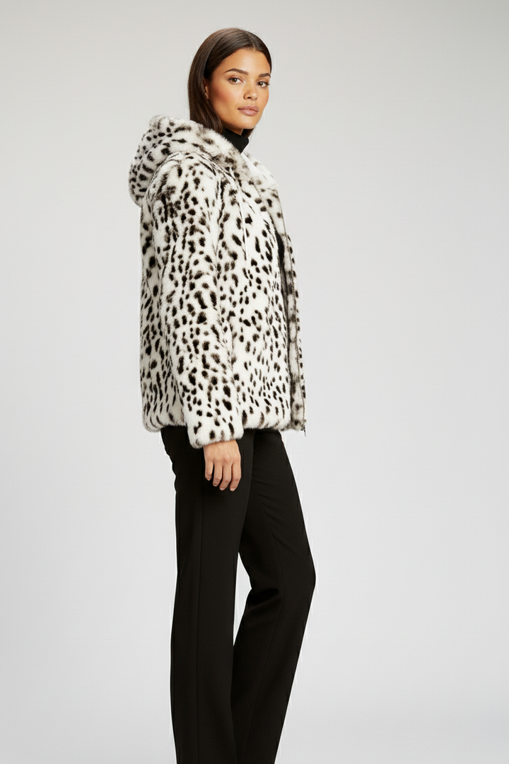 Woman wearing a leopard print coat on a plain background