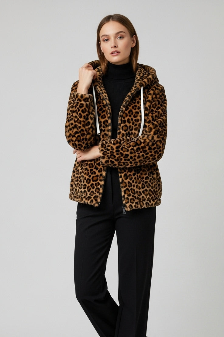 Woman wearing a leopard print jacket and black pants on a white background