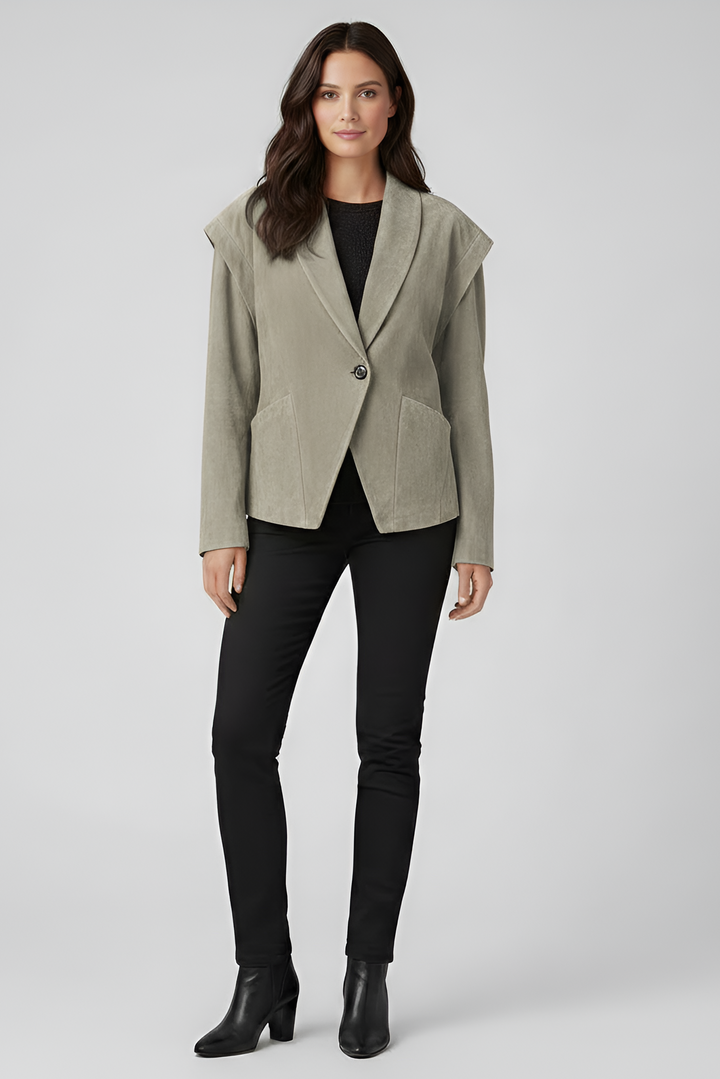 Woman wearing a light gray blazer over a black top and pants on a white background