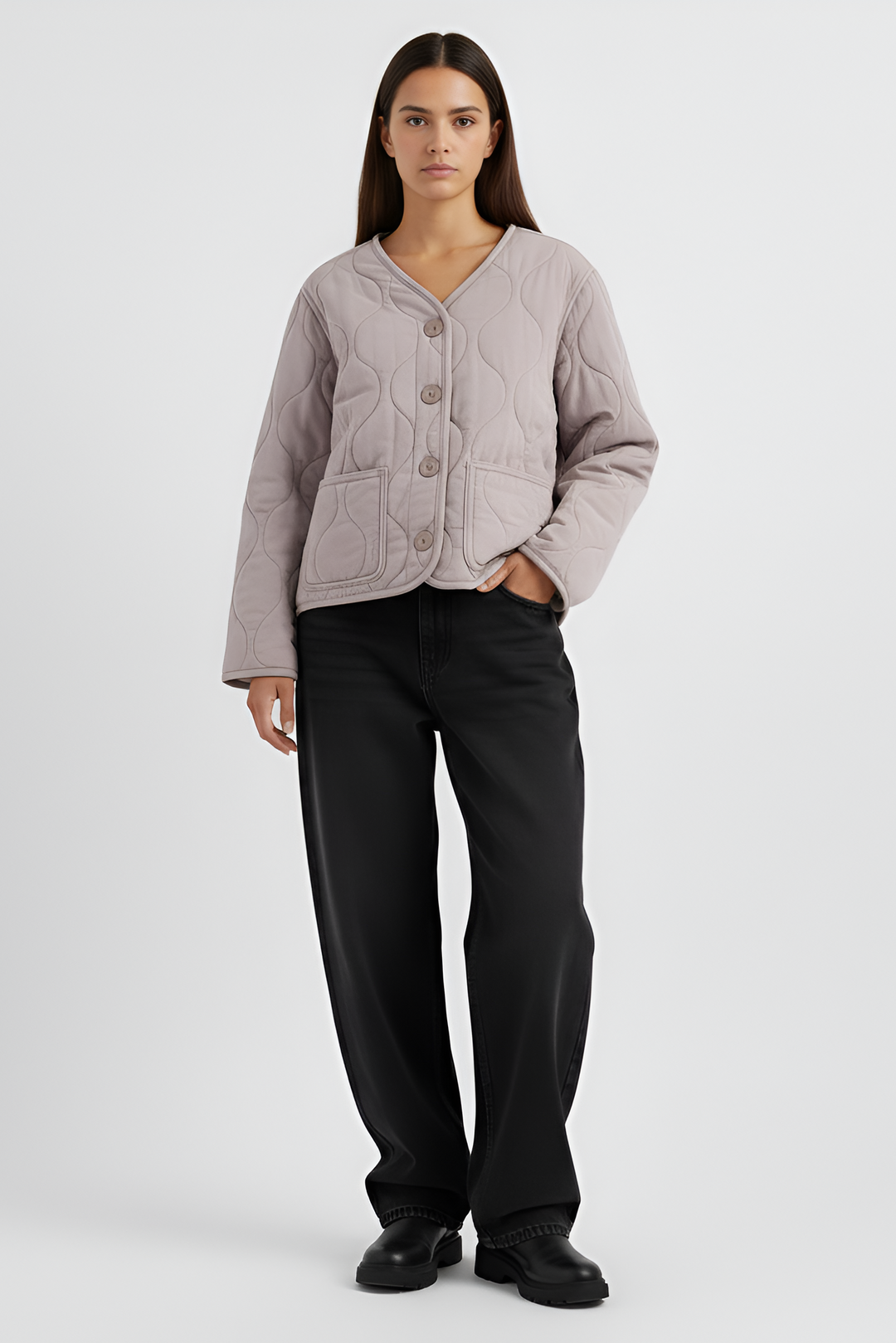 Woman wearing a light gray jacket and black pants on a white background