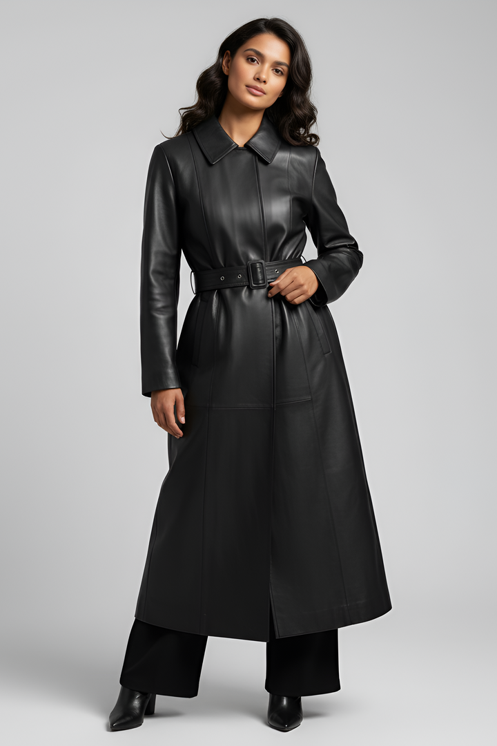 Woman wearing a long black leather coat on a gray background