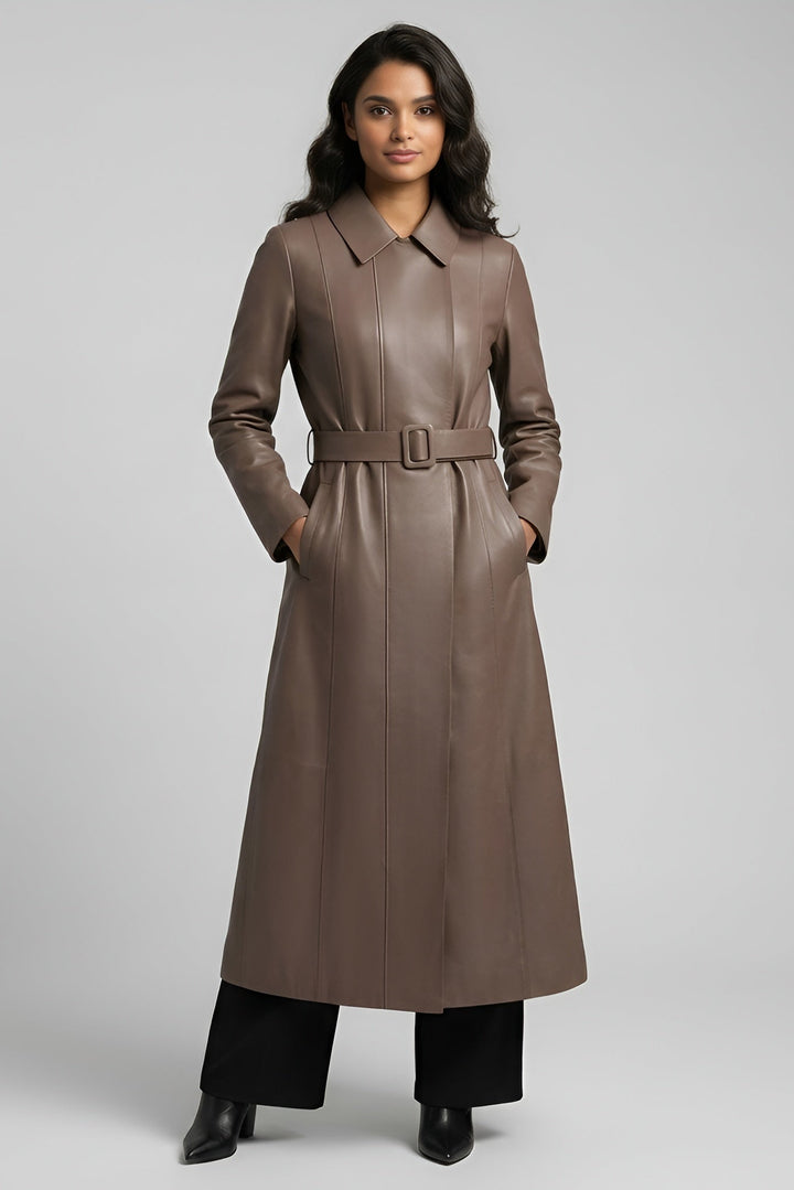 Woman wearing a long brown coat on a gray background