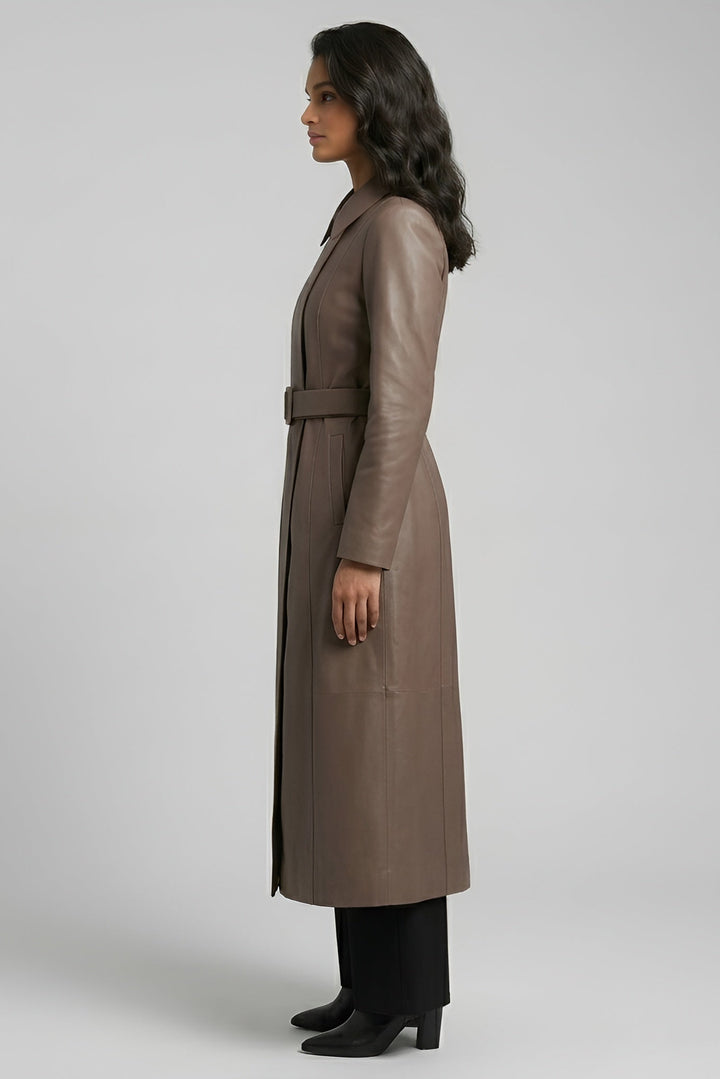 Woman wearing a long brown coat on a plain background