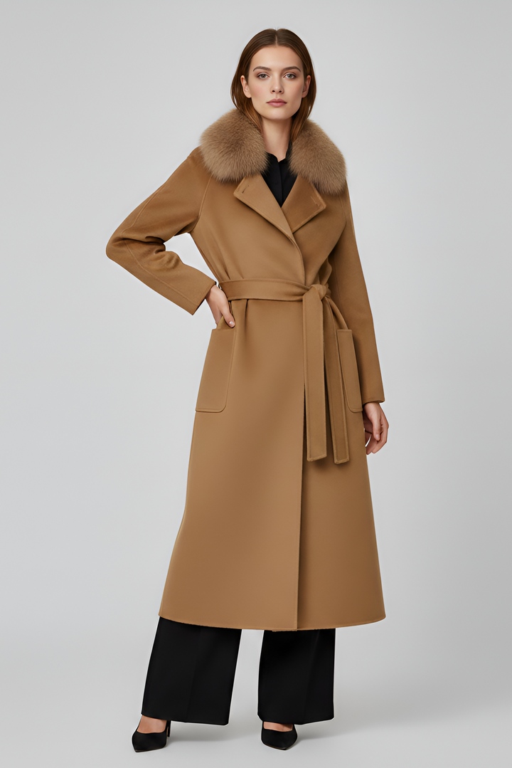 Woman wearing a long brown coat with fur collar on a light gray background