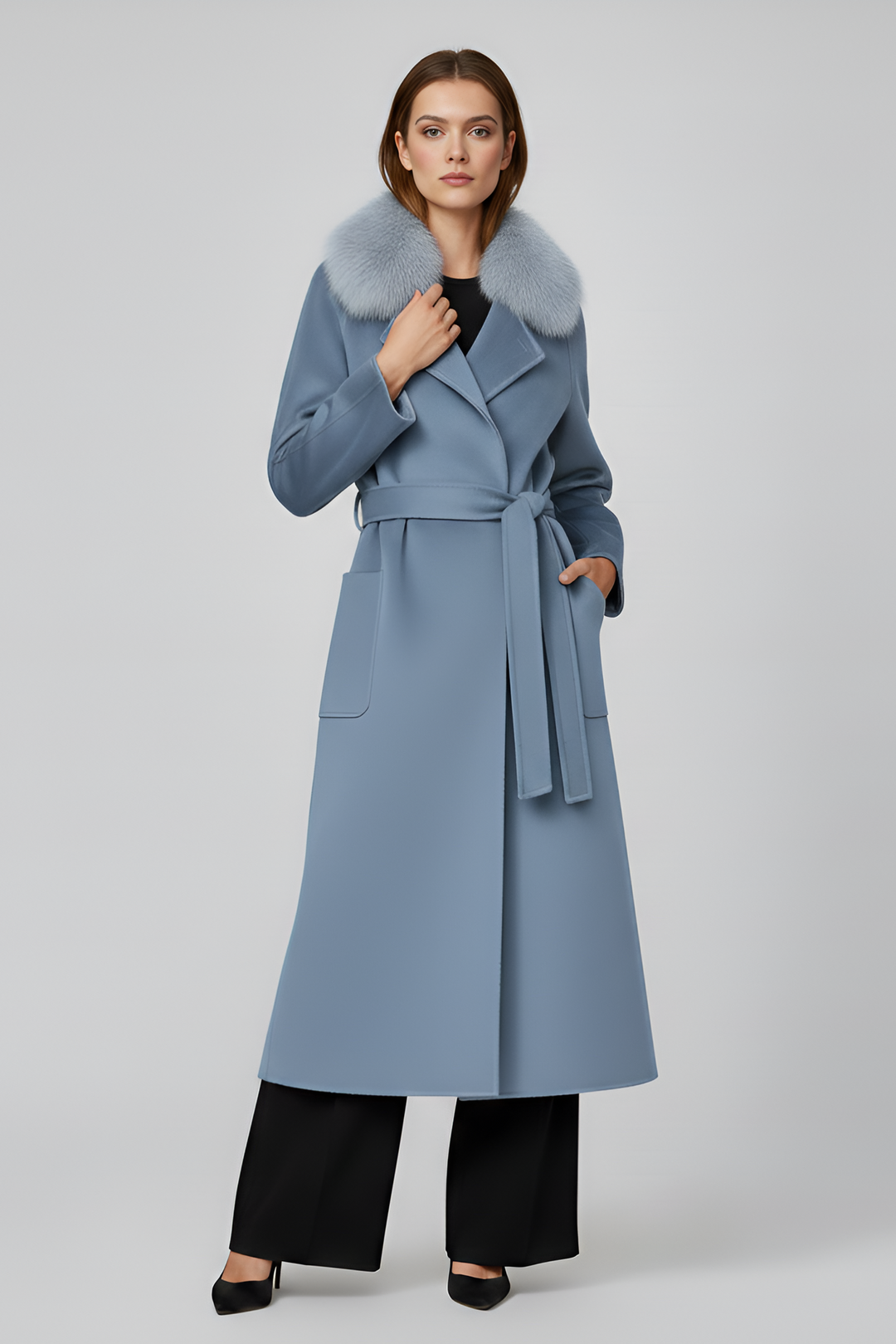 Woman wearing a long light blue coat with a fur collar on a white background