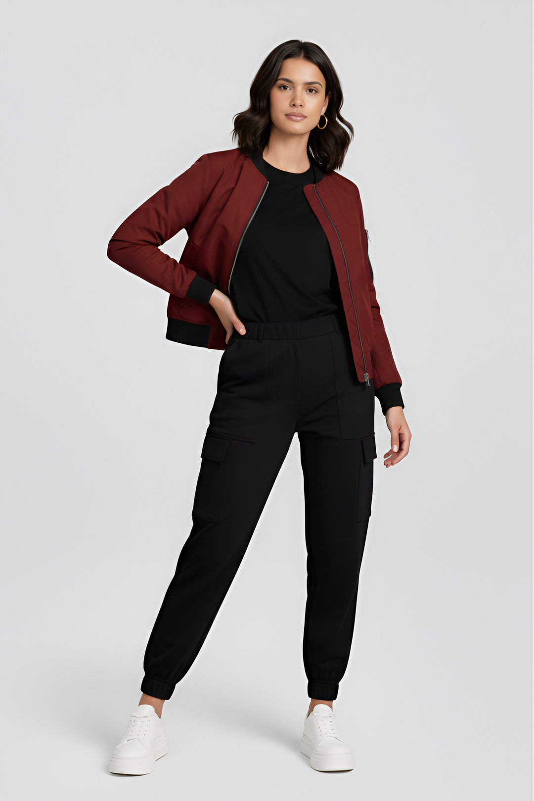 Woman wearing a red jacket, black top, and black pants on a white background