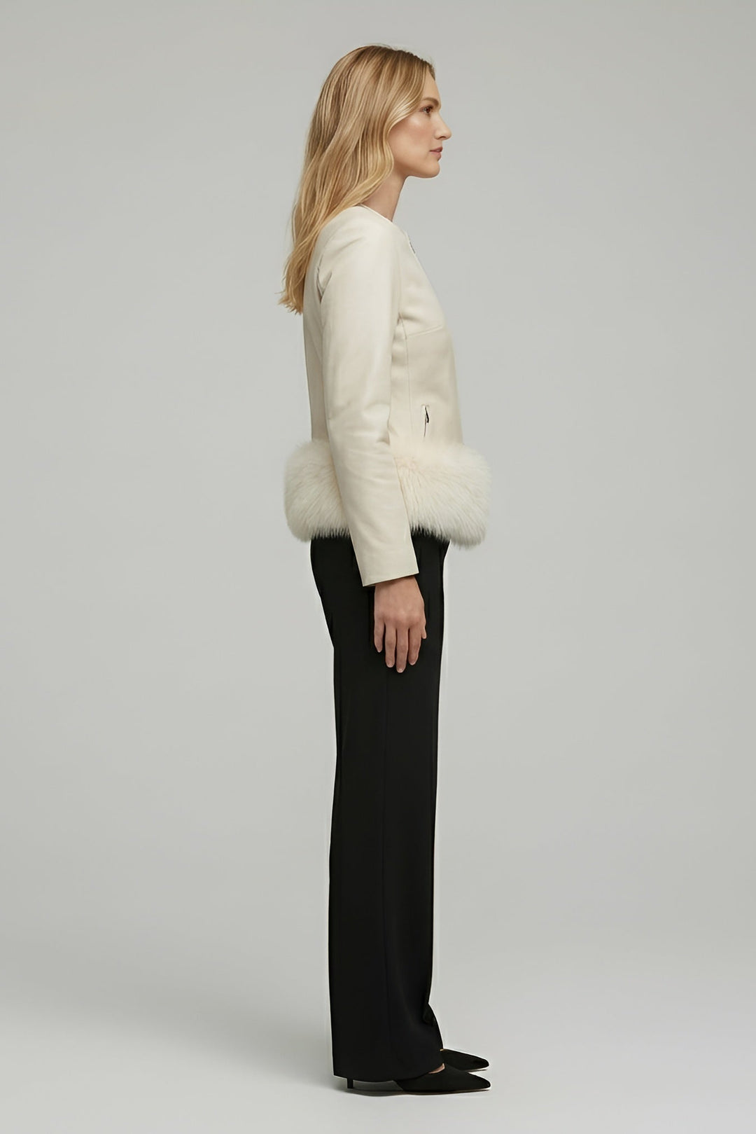 Woman wearing a white fur-trimmed jacket on a plain background