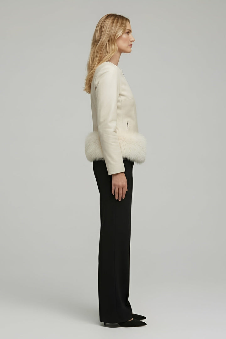 Woman wearing a white fur-trimmed jacket on a plain background